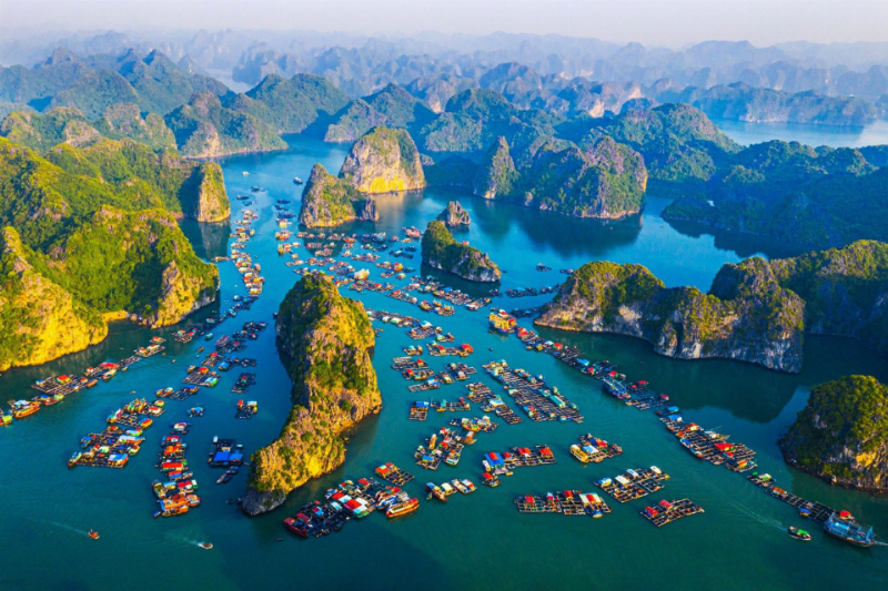 Du khách đang chèo kayak giữa các hòn đảo đá vôi trên Vịnh Lan Hạ, Cát Bà, trải nghiệm hoạt động thú vị khi du lịch biển miền Bắc.